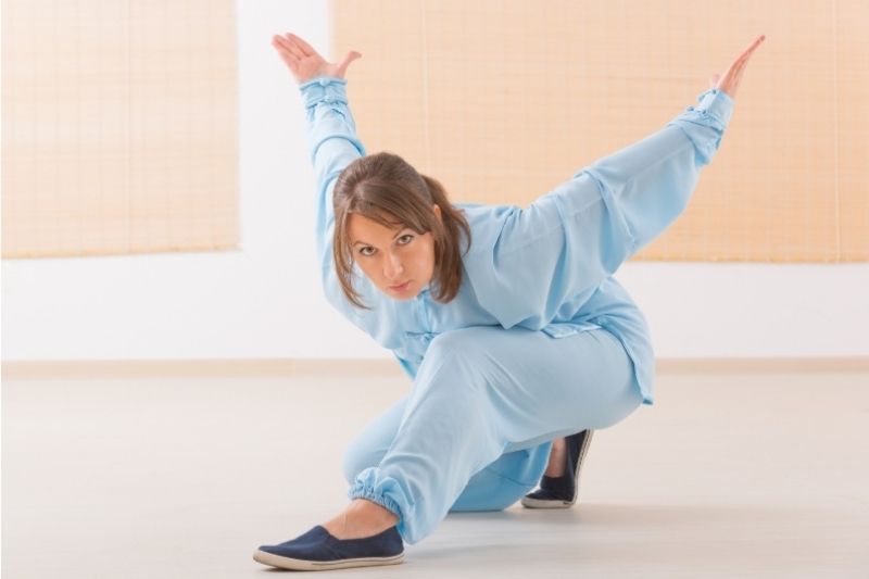 Donna pratica Qi Gong con movimenti lenti e controllati