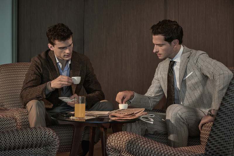 due uomini in completo elegante e cravatta bevono un caffè seduti ad un tavolino