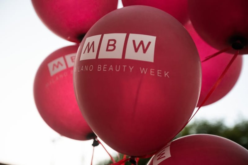 Palloncini rossi con logo MBW durante la Milano Beauty Week 2025