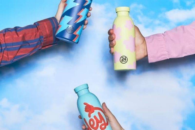 mani che tendono borracce colorate della nuova collezione 24Bottles autunno inverno 2025