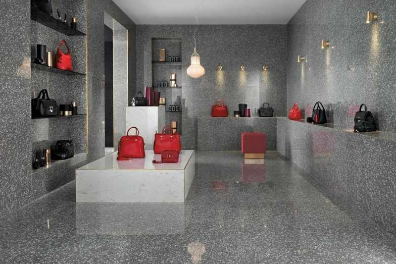 Negozio di design con rivestimenti in gres porcellanato effetto marmo, esposizione di borse eleganti e illuminazione moderna