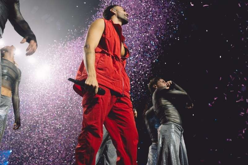 Marco Mengoni con outfit Fendi rosso durante il concerto all’Unipol Forum di Milano