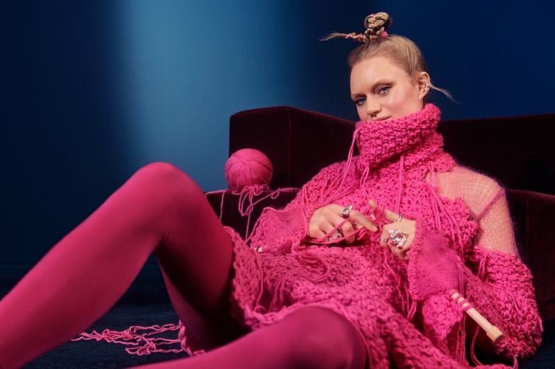 Modella in outfit magenta durante la campagna beauty Klarna per il Black Friday 2025