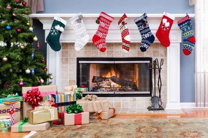 Calze della Befana appese al camino con regali e decorazioni per l’Epifania in stile Maisons du Monde