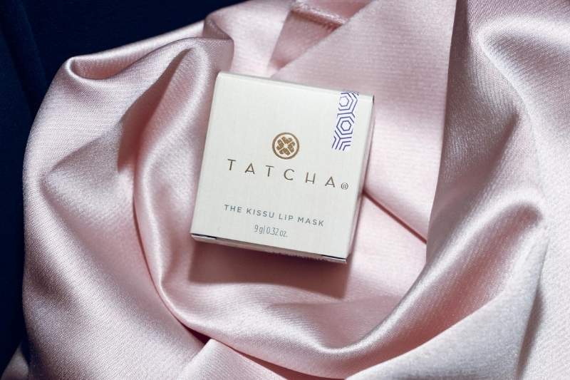 Confezione di Tatcha The Kissu Lip Mask su tessuto rosa durante la co-lab con Mantù alla Milano Fashion Week