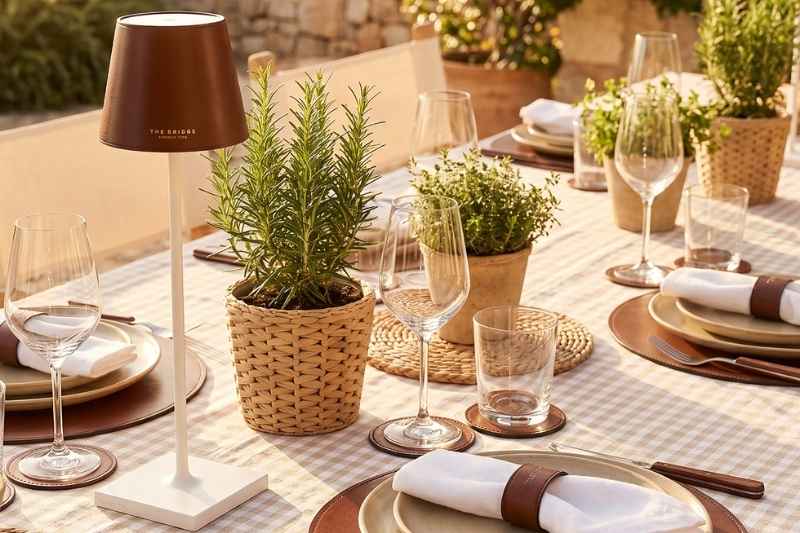Tavola apparecchiata con accessori in pelle The Bridge Home Decor e lampada Poldina personalizzata dal brand