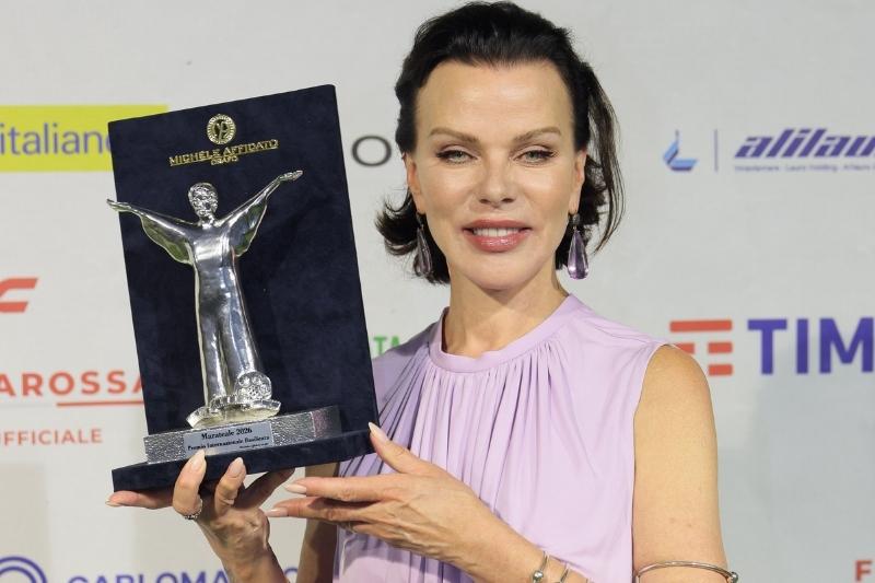 Debi Mazar posa con il premio ricevuto al Marateale 2026 con un abito lilla