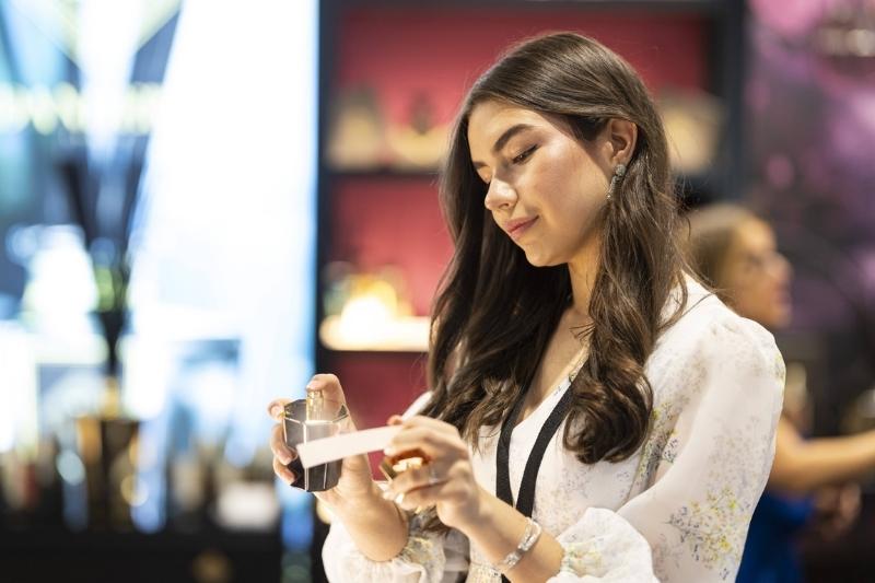 Visitatrice scopre una fragranza artistica durante un evento Esxence dedicato alla profumeria di nicchia