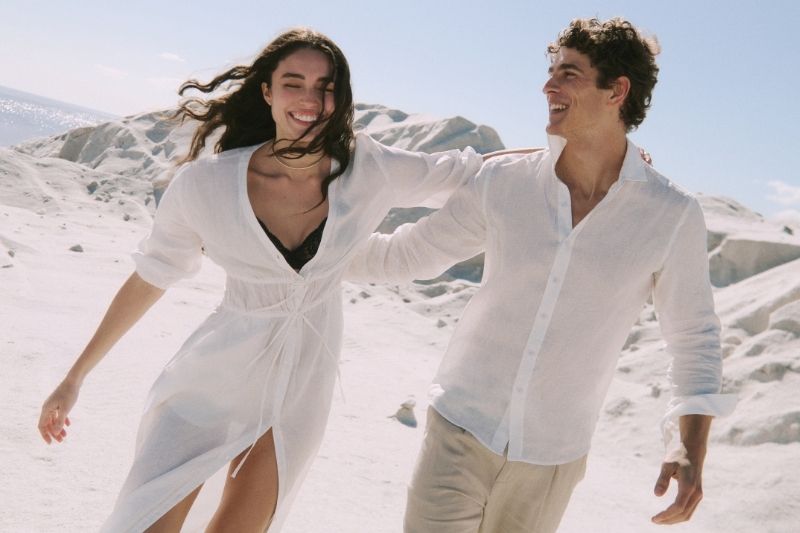 Modella e modello indossano look bianchi e beige in lino Falconeri tra distese di sale nella campagna Estate 2026