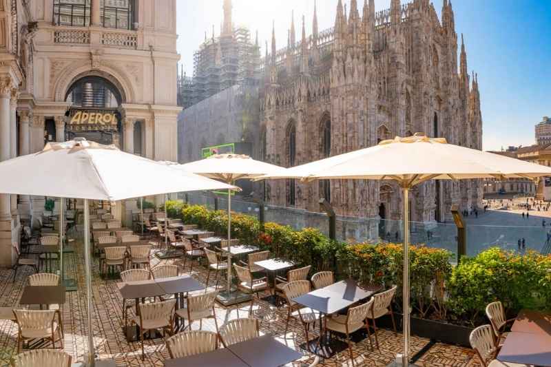 Terrazza Aperol affacciata sul Duomo di Milano con tavoli, ombrelloni e sedute outdoor della collezione Piper di Roda
