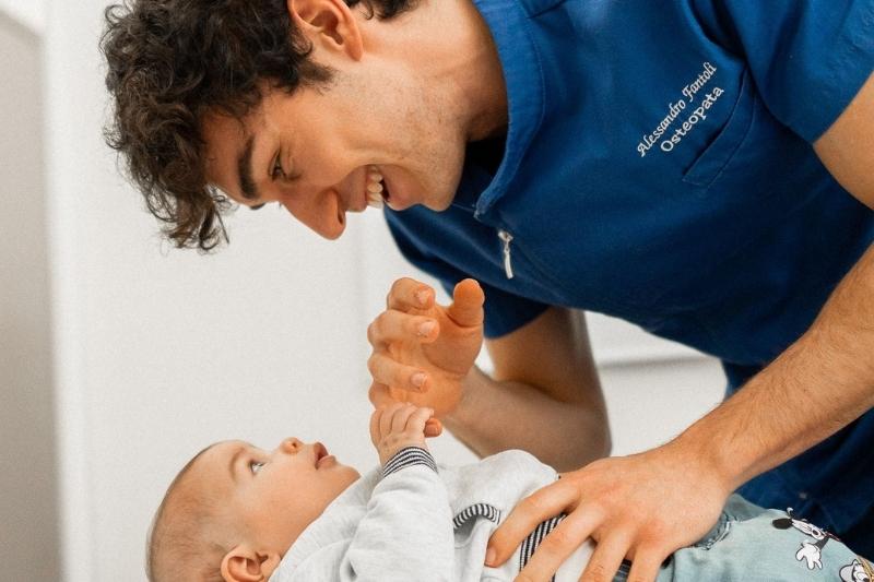 L'osteopata pediatrico Alessandro Fantoli con un neonato nella campagna Walkey Happy Planet Barefoot Spring Summer 2026