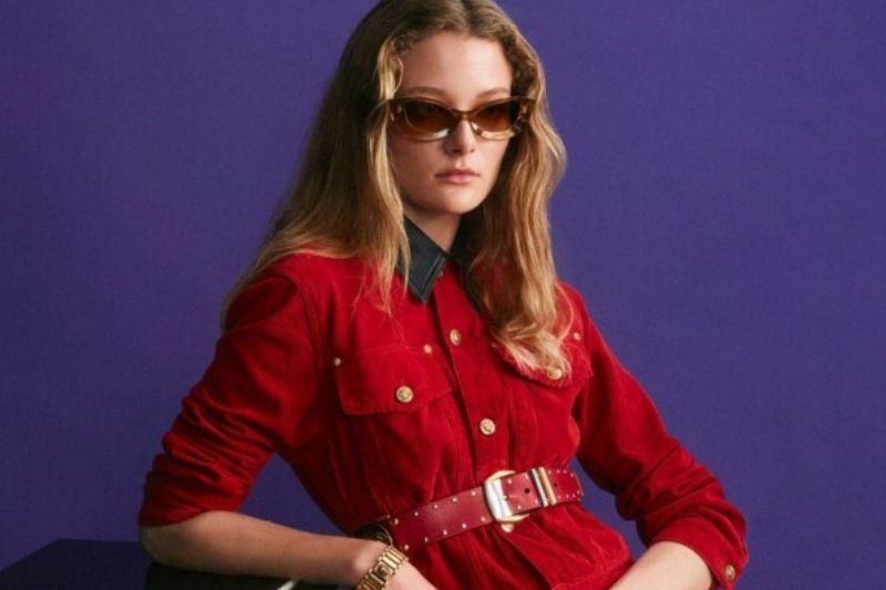 Modella indossa un abito-camicia rosso della campagna Versace Autunno Inverno 2026-2027 fotografata da Steven Meisel